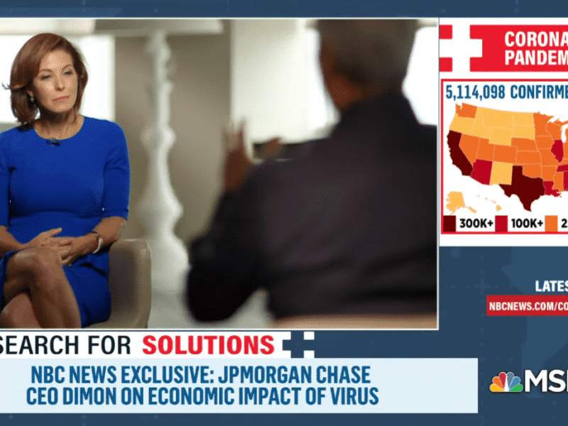 A screencap of an MSNBC interview with a bottom banner that reads NBC News Exclusive: JP Morgan Chase CEO Dimon on Economic Impact of Virus. Above that banner is one that reads Search for Solutions. Dimon, a white woman with a light brown bob, wears a blue dress and sits cross-legged. To her right is a map of the U.S. coronavirus cases, noting 5,114,098 confirmed cases and areas where there are more than 300K+, 100K+, 25K+, and 1K+ cases. (California, New York, Florida, and Texas all have 300K+.)