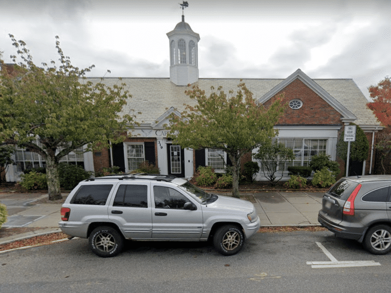 A car parallel parked outside of a building.