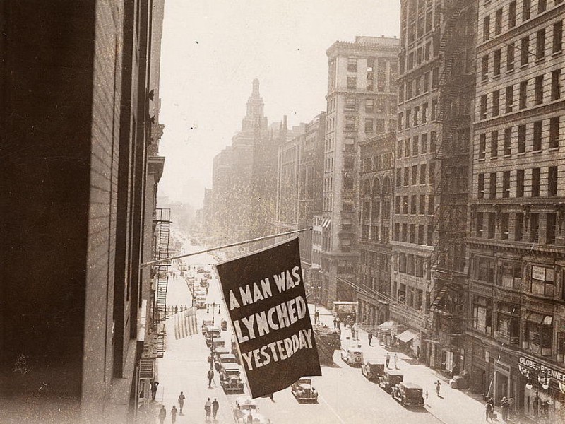A flag that reads "A man was lynched yesterday" hangs from the window of the NAACP headquarters on 69 Fifth Ave., New York City.