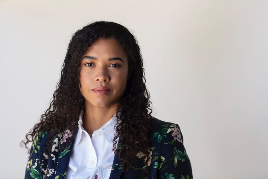 Headshot of Cerise Castle. She stands in front of a white background and is wearing a floral blazer.