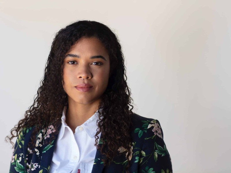 Headshot of Cerise Castle. She stands in front of a white background and is wearing a floral blazer.