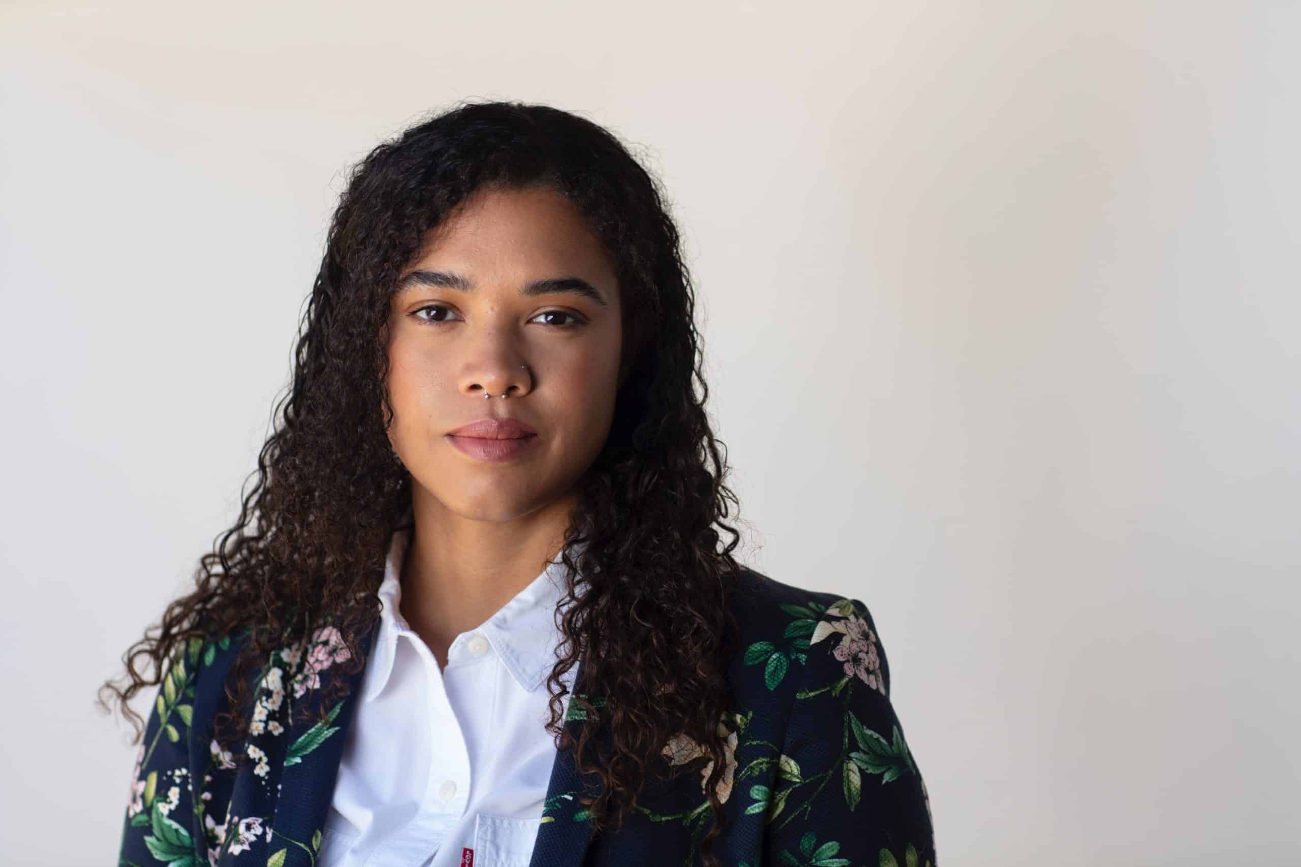 Headshot of Cerise Castle. She stands in front of a white background and is wearing a floral blazer.
