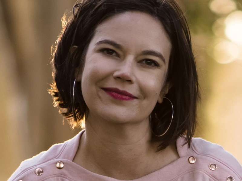 Headshot of Cristina Escobar. Her background is outside and blurred.