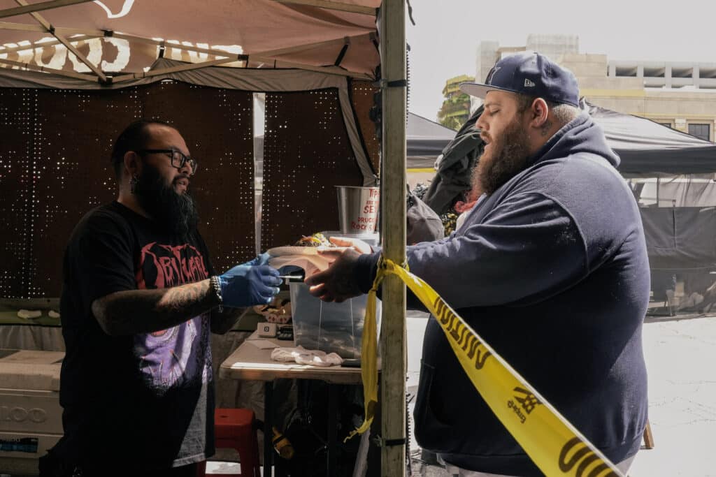 Co-founder Alex Garcia hands off a plate of tacos to a visitor.