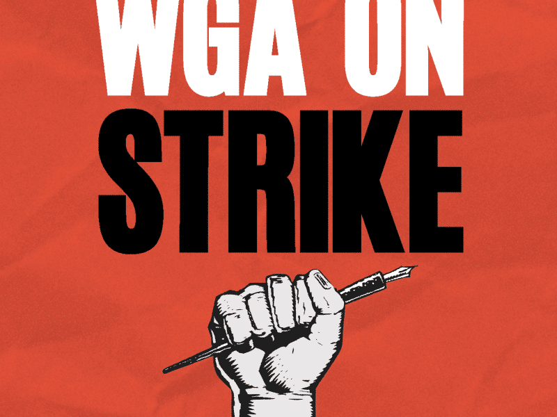 A fist holding up a pen is displayed on a red background. Text above reads WGA on strike in all caps.