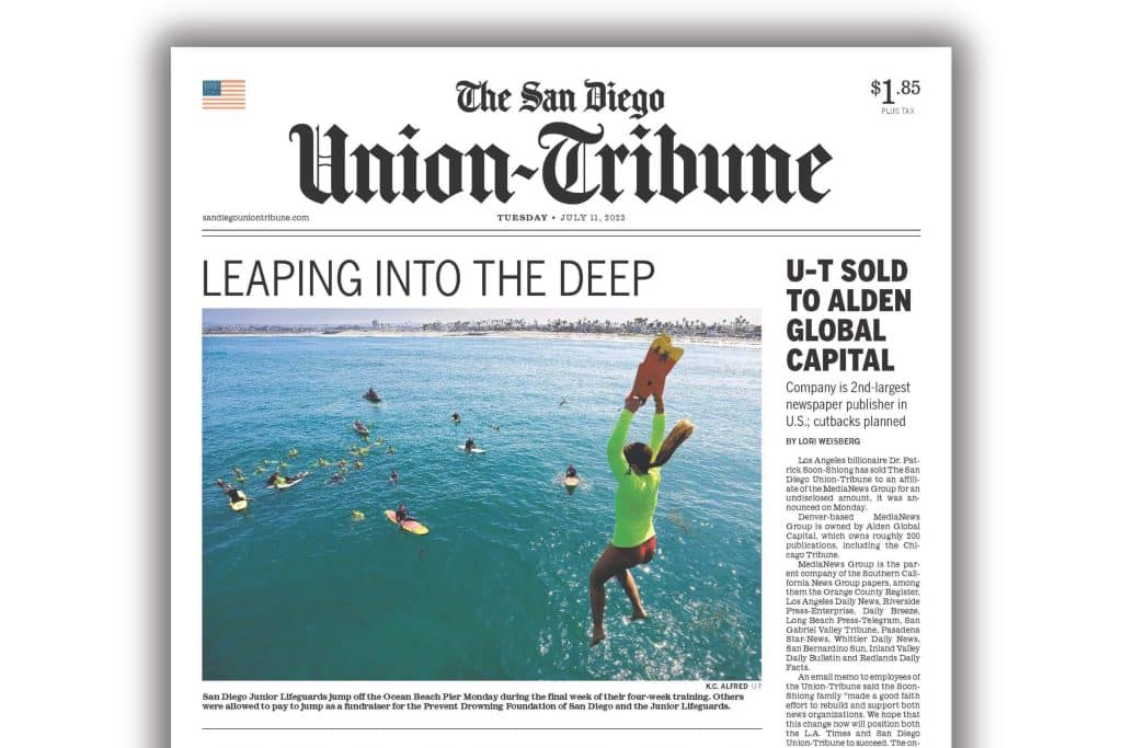 A screenshot of the front page of the July 11 e-newspaper edition of the San Diego Union-Tribune. There are two front-page stories; the more prominent one is called Leaping Into the Deep and is positioned above a photo of divers jumping into the ocean. The other story pictured is off to the side: U-T Sold to Alden Global Capital. The tease reads "Company is 2nd-largest newspaper publisher in U.S.; cutbacks planned."