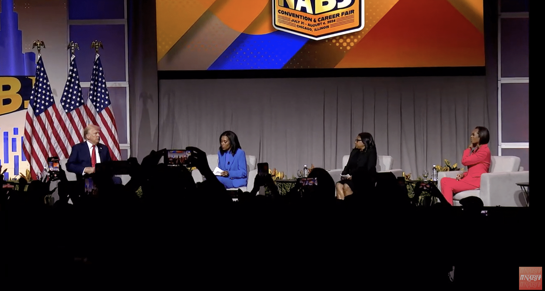 Former president Donald Trump sits in front of three American flags on stage with three Black women: ABC News host Rachel Scott, Semafor political reporter Kadia Goba, and Fox News host Harris Faulkner, from left to right. 