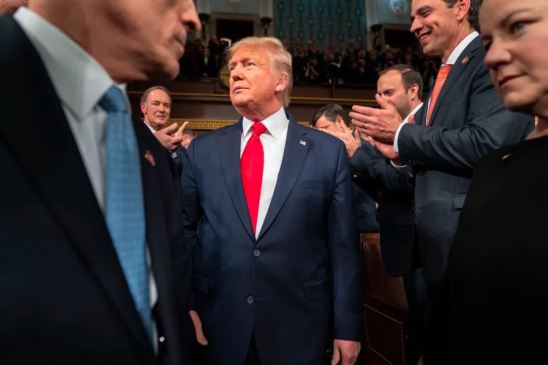 Donald Trump in a suit surrounded by policymakers.