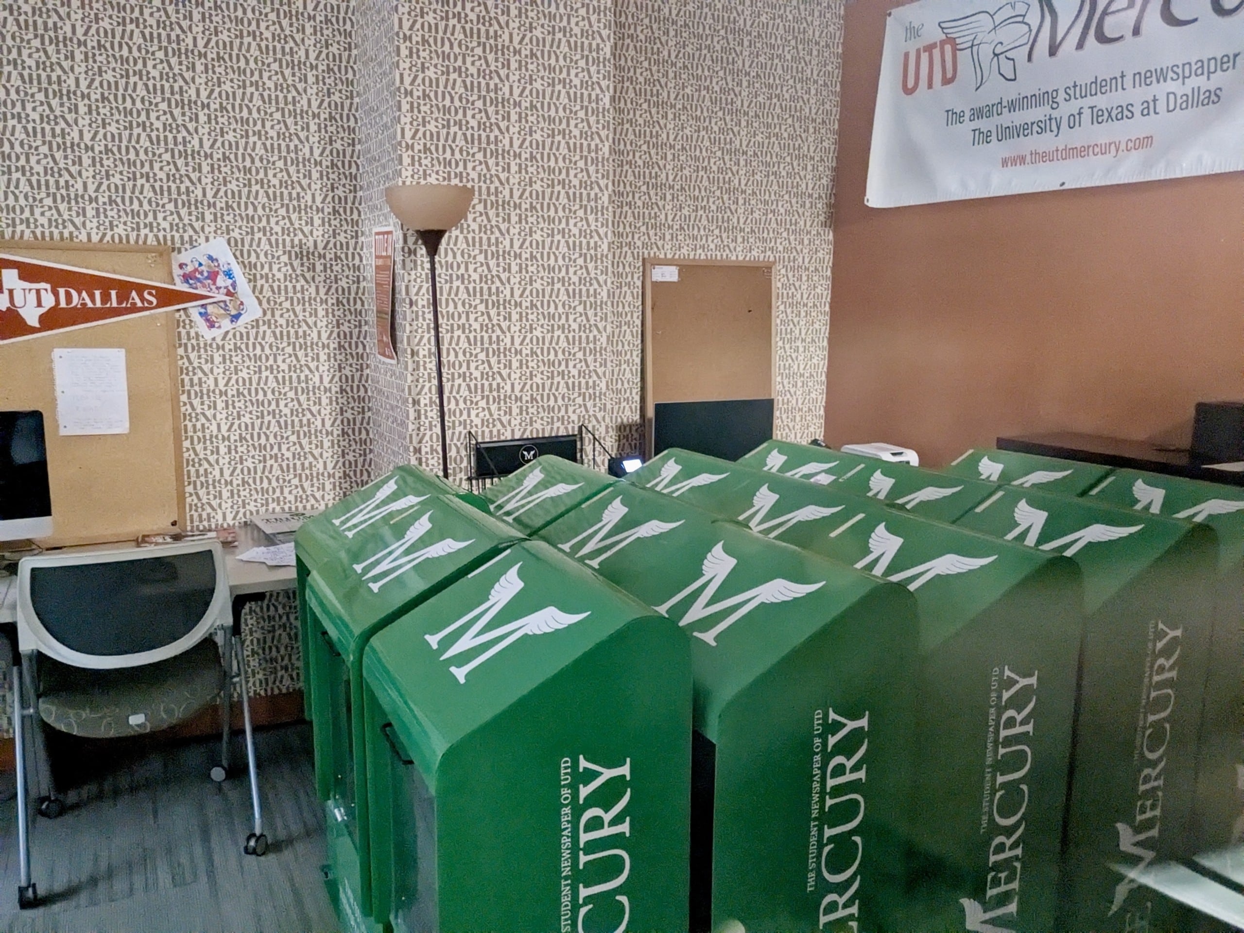 Fourteen newsstands sit neatly arranged in the unoccupied Mercury workroom. 