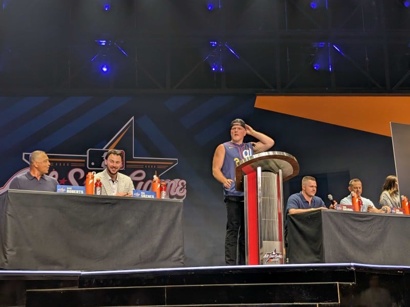 From left to right: Dave Roberts, Paul Skenes, Pat McAfee, Tarik Skubal, and Aaron Boone on the press conference stage at All-Star media day in Atlanta.