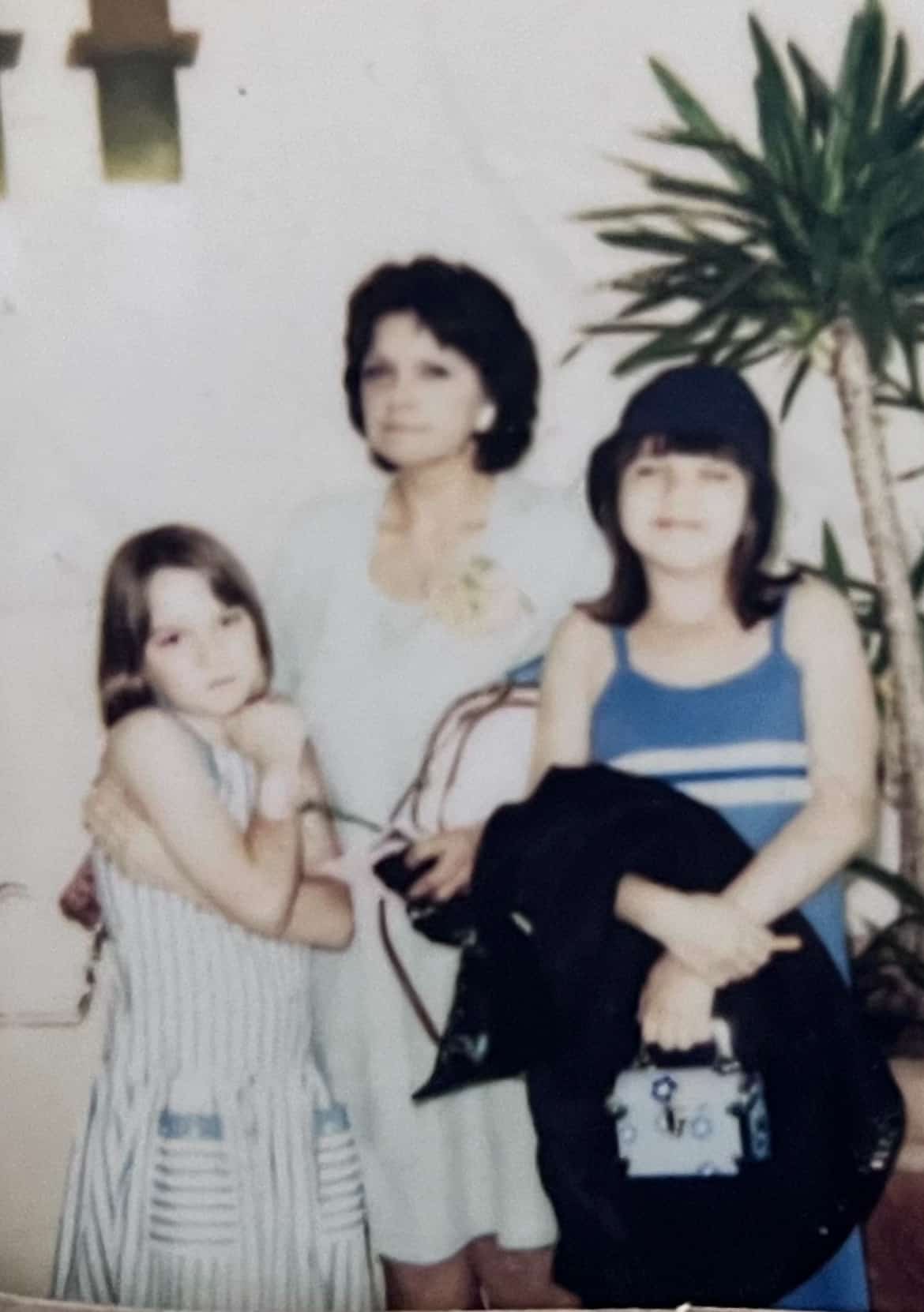 A family photo of the author's sister as a child, their mom, and the author as a child.