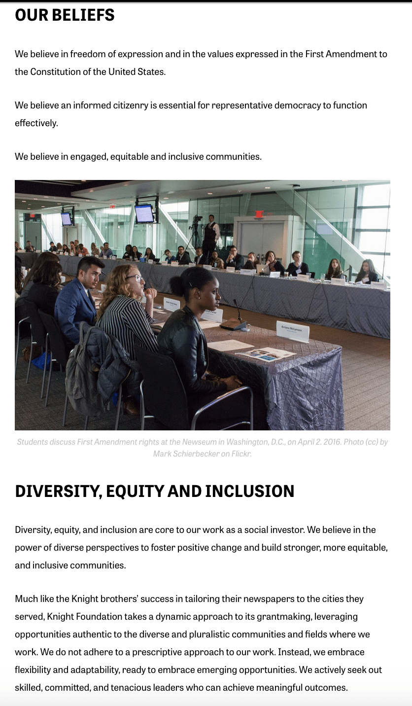 A screenshot of the Knight Foundation 'About' page with two sections and a photo. The first reads "Our Beliefs" and has three statements: We believe in freedom of expression and in the values expressed in the First Amendment to the Constitution of the United States. 
We believe an informed citizenry is essential for representative democracy to function effectively.
We believe in engaged, equitable and inclusive communities.
Then a photo of students sitting at two long tables of a mix of races, with a Black and Latine student prominently featured, captioned "Students discuss First Amendment rights at the Newseum in Washington, D.C. on April 2, 2016. Photo (cc) by Mark Schierbecker on Flickr." 
The Diversity, Equity and Inclusion section reads:


Diversity, equity, and inclusion are core to our work as a social investor. We believe in the power of diverse perspectives to foster positive change and build stronger, more equitable, and inclusive communities.

Much like the Knight brothers’ success in tailoring their newspapers to the cities they served, Knight Foundation takes a dynamic approach to its grantmaking, leveraging opportunities authentic to the diverse and pluralistic communities and fields where we work. We do not adhere to a prescriptive approach to our work. Instead, we embrace flexibility and adaptability, ready to embrace emerging opportunities. We actively seek out skilled, committed, and tenacious leaders who can achieve meaningful outcomes.
