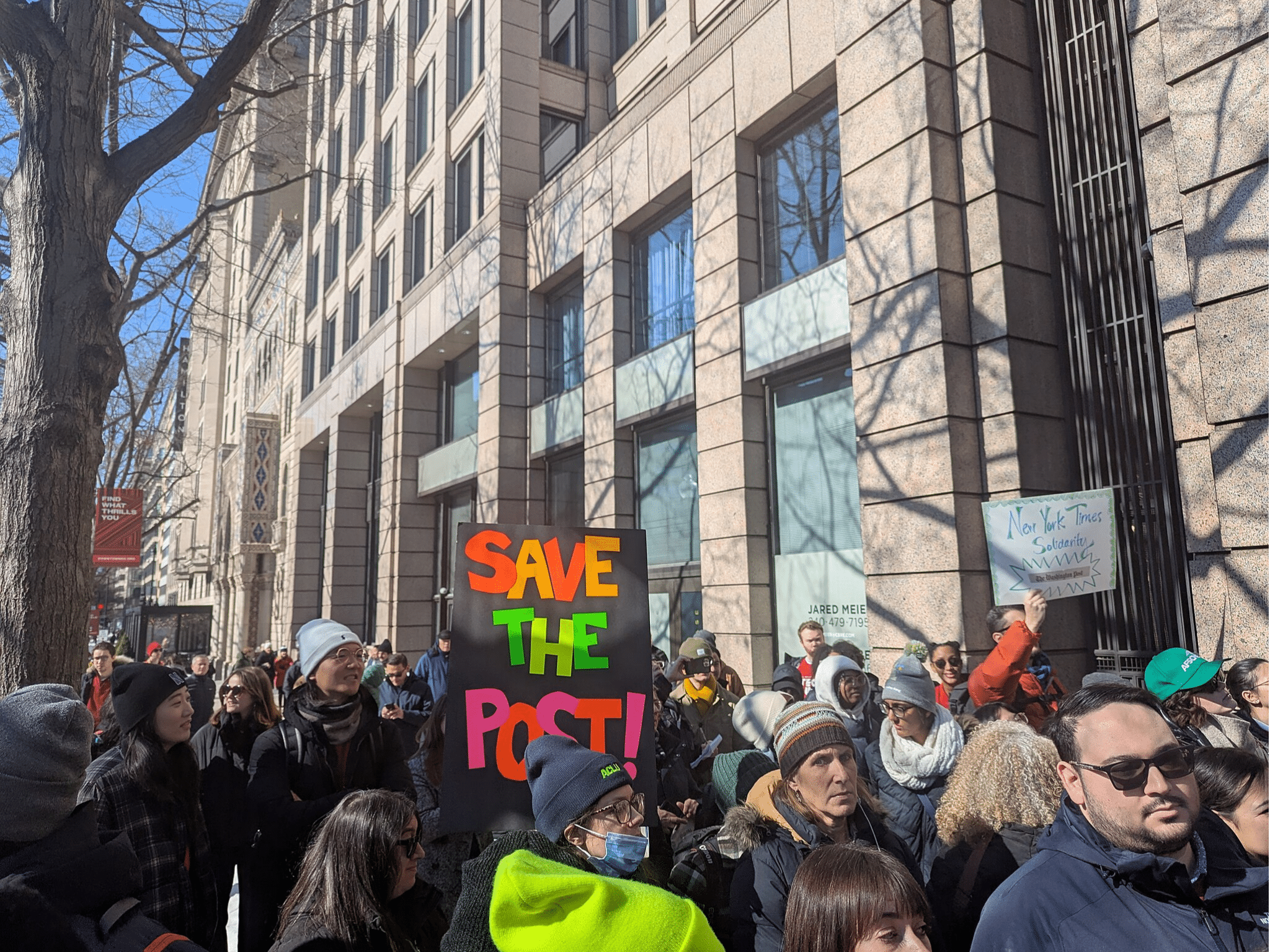 A photo from a Feb. 5 rally supporting the fired Post reporters, with a sign centered in the frame that says "Save the Post".