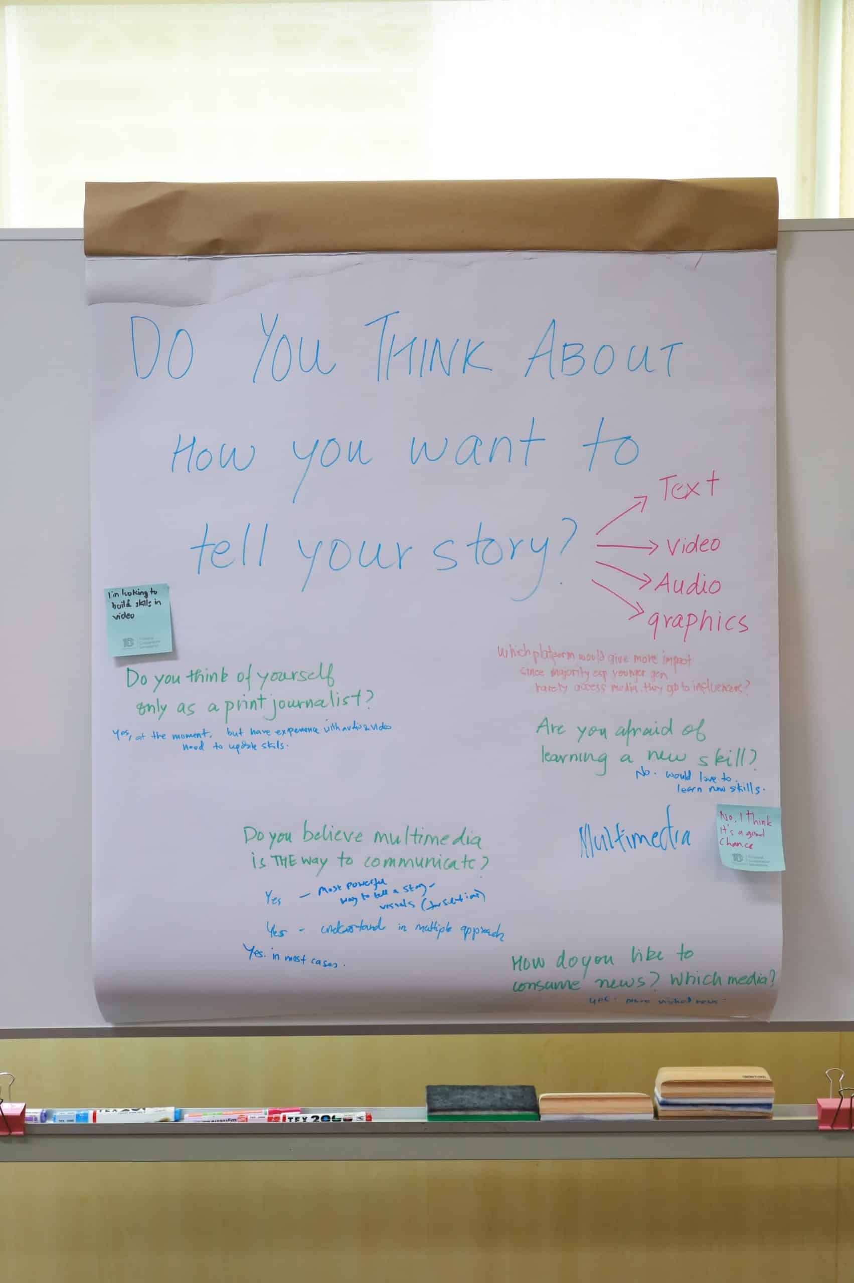 A large notepad with notes surrounding a question at the top: Do you think about how you want to tell your story? (via text, audio, graphics, video)
There are five other questions, which all have varying comments, on the pad: 
Do you think of yourself only as a print journalist? (One comment written below: Yes, at the moment, but have experience with audio, video. Need to update skills. Another comment stickied on: I'm looking to build skills in video.)
Are you afraid of learning a new skill? (Comments: No - would love to learn new skills. No, I think it's a good chance.)
Which platform would give more impact since majority, esp. younger gen, rarely access media they go to influence? 
Do you believe multimedia is the way to communicate? (Comments: Yes - most powerful way to tell a story - visuals (+ sections). Yes - understand in multiple approach. Yes. In most cases.)
How do you like to consume news? Which media? 