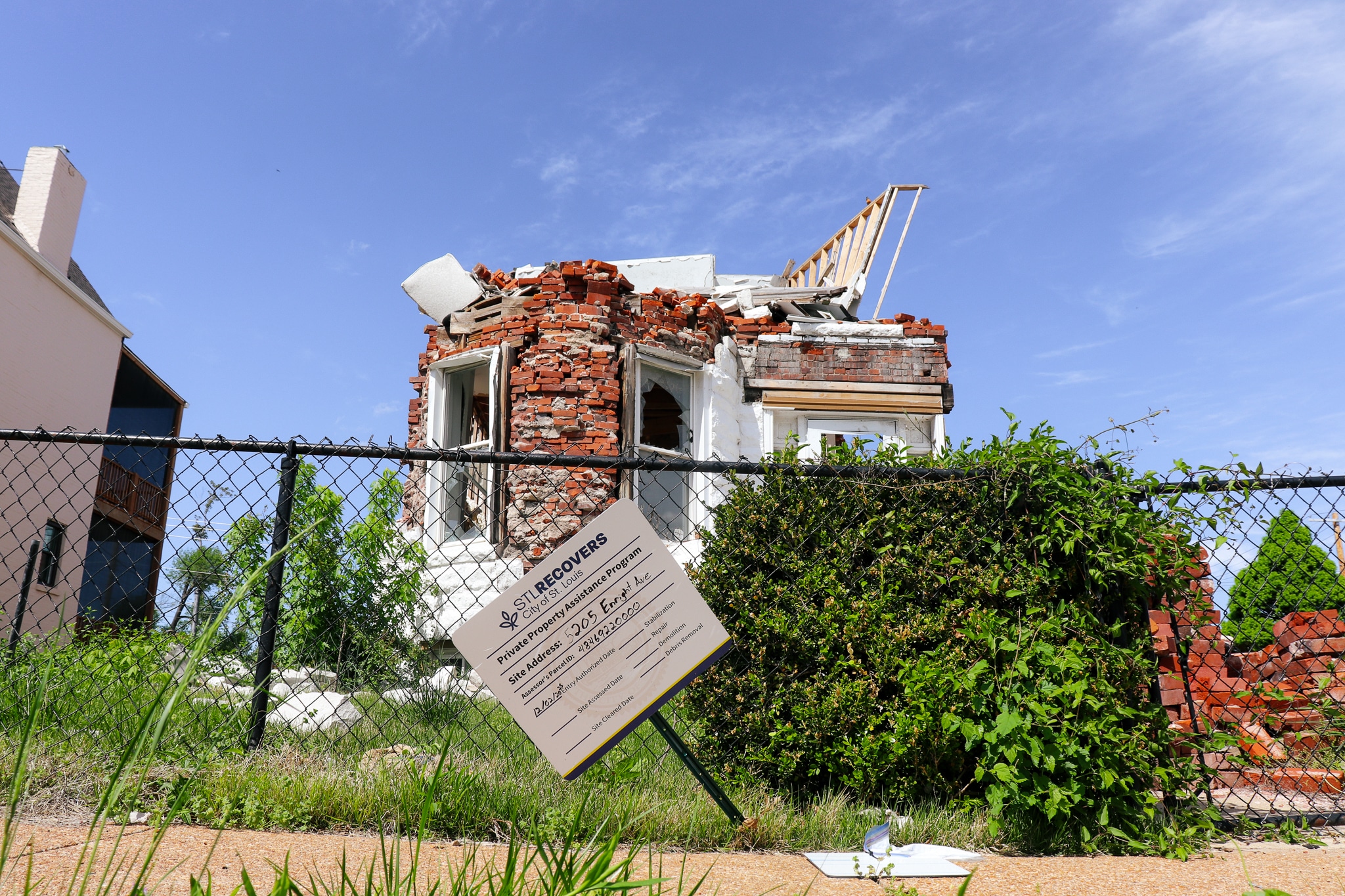 A brick building damaged by tornadoes in North St. Louis. The entire roof and top floor of the building have been blown off, and the remaining first floor windows are shattered.